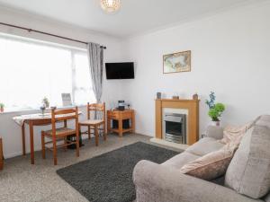 a living room with a couch and a table at 90 Bay View in New Romney