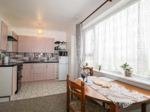 a kitchen with a wooden table and a dining room at 90 Bay View in New Romney