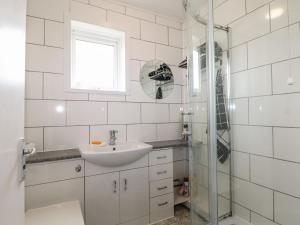 a white bathroom with a sink and a shower at 90 Bay View in New Romney +7 photos