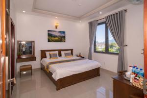 a bedroom with a bed and a window at Côn Sơn Victory Hotel in Con Dao