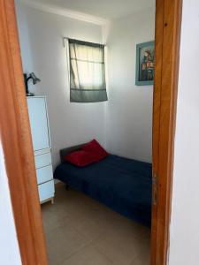 a small bedroom with a blue bed and a window at Sea view apartments in Caesarea +21 photos