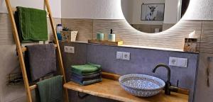 a bathroom with a sink and a mirror at Ferien im Kühbergstadl in Bischofsmais +28 photos