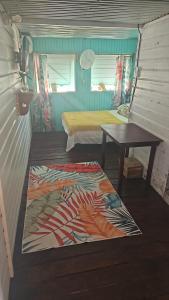 a small room with a bed and a table at Tio Toms Guesthouse in Bastimentos +4 photos