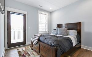 a bedroom with a bed with a wooden headboard and a window at Luxurious Eastern Shore Getaway in Milton