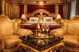 a room with two chairs and a table with champagne glasses at Prezident Palace Belgrade - Rooftop Pool & Spa Hotel in Belgrade