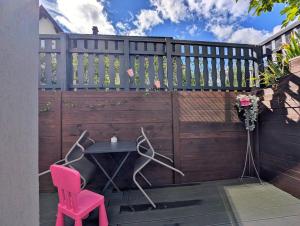 a patio with a fence and a table and chairs at Aux cigognes de Blotzheim in Blotzheim