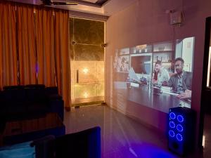 a bar in a room with a screen with two men at Amigos Farm in Lucknow