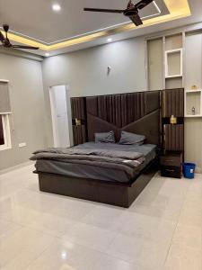a bedroom with a large bed with a ceiling fan at Amigos Farm in Lucknow