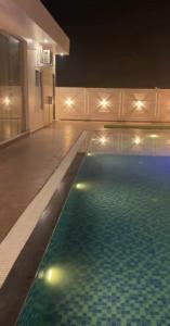 a swimming pool in a house at night at Amigos Farm in Lucknow