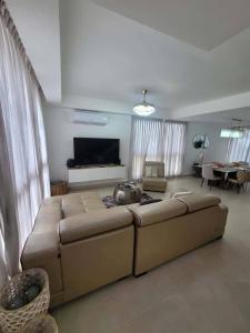 a living room with a large couch and a television at Damani Modern Pool Villa Escape in Punta Cana