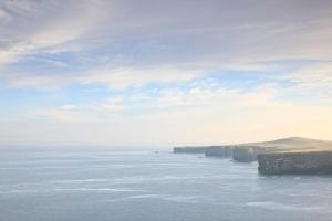 a view of the ocean with cliffs in the distance at Stella Maris Hotel in Kilkee
