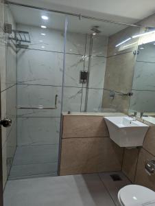 a bathroom with a shower and a sink at Oxyrich Business Class Hotel in Madikeri