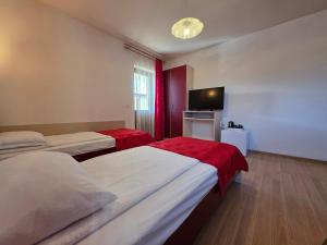 a hotel room with two beds and a flat screen tv at Pensiunea Maria , Floresti in Floreşti +25 photos
