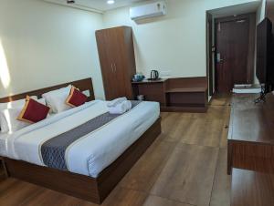 a bedroom with a large bed in a room at Oxyrich Business Class Hotel in Madikeri