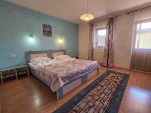 a bedroom with a bed and a rug in it at Pensiunea Maria , Floresti in Floreşti