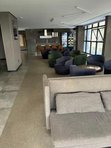 a lobby with a couch and chairs in a building at TIME Ponta Verde in Maceió