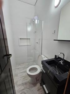 a bathroom with a toilet and a shower and a sink at Schulz Pousada in Joinville