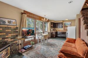 a living room with a couch and a table and a kitchen at Singer Cabin 2 in Ridgway