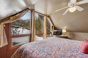 a bedroom with a bed and a large window at Singer Cabin 2 in Ridgway