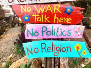 a sign that says no war talk here no policies no religion at Pemsee's Tree Town - Eco Treehouse Hostel in Sauraha