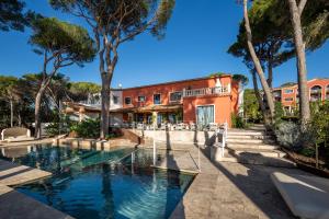 a house with a swimming pool in front of a building at Hotel Cala del Pi - Adults Only in Platja d'Aro