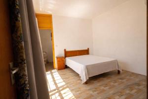 a bedroom with a white bed and a wooden floor at Hope Villa in Calodyne