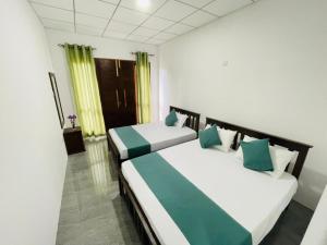 two beds in a room with green and white at Diyathna Nuwarawewa in Anuradhapura