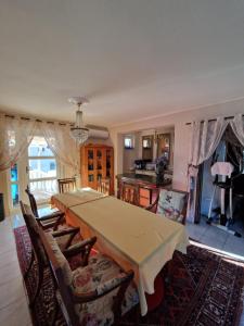 a dining room with a table and a kitchen at Stara Ruža in Gračanica