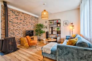 a living room with a couch and a brick wall at L'échappée du Cotentin in Cherbourg en Cotentin