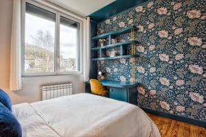 a bedroom with a bed and a desk and a window at L'échappée du Cotentin in Cherbourg en Cotentin