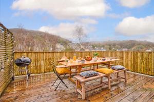 a wooden deck with a table and chairs on it at L'échappée du Cotentin in Cherbourg en Cotentin