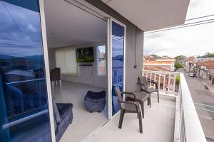 a balcony with chairs and a table on a building at amplio y lujoso apartasuite en el centro in Cartago