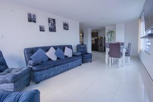 a living room with a blue couch and a table at amplio y lujoso apartasuite en el centro in Cartago