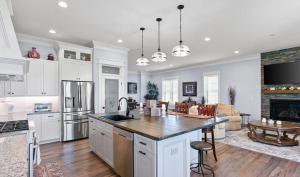a kitchen with white cabinets and a living room at Luxurious Eastern Shore Getaway in Milton