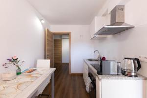 a kitchen with white walls and a counter top at Trajadinha do Lima Apart in Ponte de Lima +19 photos