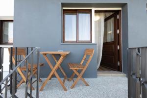 a pair of chairs and a table next to a door at Trajadinha do Lima Apart in Ponte de Lima