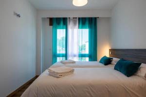 a bedroom with two beds with towels on them at Trajadinha do Lima Apart in Ponte de Lima