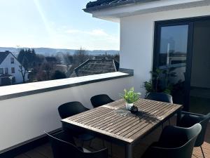 a wooden table and chairs on a balcony at Apartment Sonnenblick in Bohmte