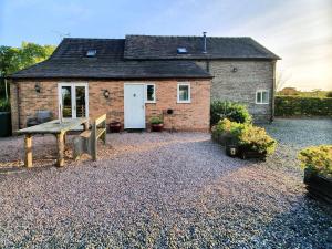 a small brick house with a bench in front of it at Howards End in Middleton on the Hill