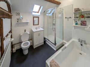 a bathroom with a toilet and a shower and a tub at Howards End in Middleton on the Hill +12 photos