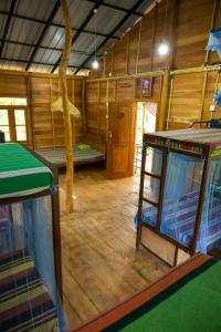 a room with wooden floors and a room with a table at Sigiriya Rastha Hostel in Sigiriya