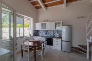 a kitchen with a table and a refrigerator at Villa Belvedere - Helloelba in Santa Caterina