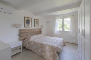 a white bedroom with a bed and a window at Villa Belvedere - Helloelba in Santa Caterina