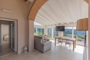 a living room with a couch and a table with chairs at Villa Belvedere - Helloelba in Santa Caterina