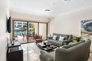 a living room with a couch and a table at PC103 - easy Pool Access - Perfect for family in Palm-Eagle Beach