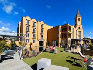 a building with a courtyard with grass and a clock tower at Riverfront Villa 069 in Terre Rouge
