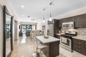 a kitchen with wooden cabinets and a kitchen island with a table at PC103 - easy Pool Access - Perfect for family in Palm-Eagle Beach