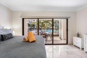 a bedroom with a bed and a view of a pool at PC103 - easy Pool Access - Perfect for family in Palm-Eagle Beach +56 photos