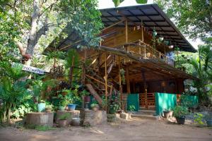 a wooden house with trees and plants in front of it at Sigiriya Rastha Hostel in Sigiriya
