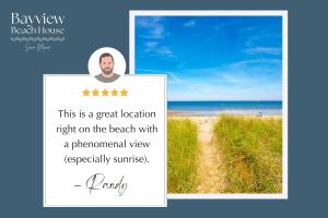 a picture of a beach with a man on a sign at Beachfront and only 30 Steps To Beach in Saco +42 photos